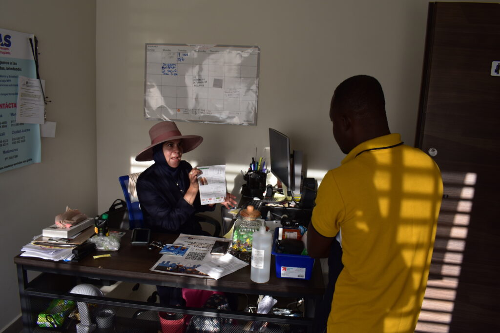 Sonia Tinoco García, president and founder of the Latina Muslim Foundation, goes over paperwork with a migrant from West Africa at the Albergue Assabil shelter in Tijuana, Mexico. 